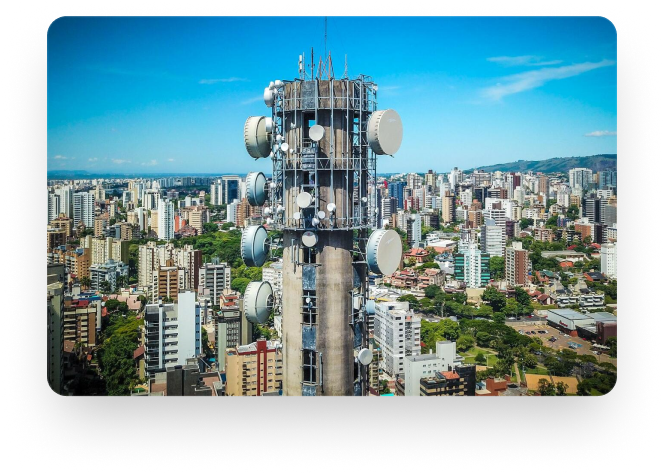 Antenas de telecomunicações e ao fundo uma cidade cheia de predios.