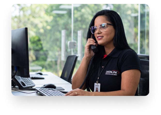Atendente da área de vendas atendendo telefone uniformizada com a camiseta da datalink.