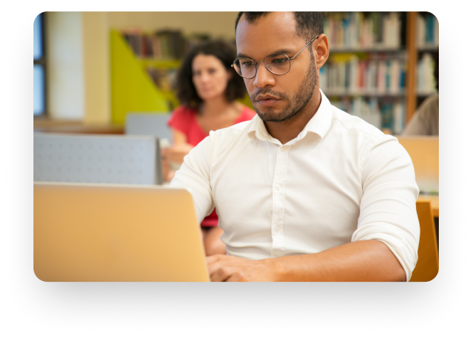 Homem sentado com computador estudando.